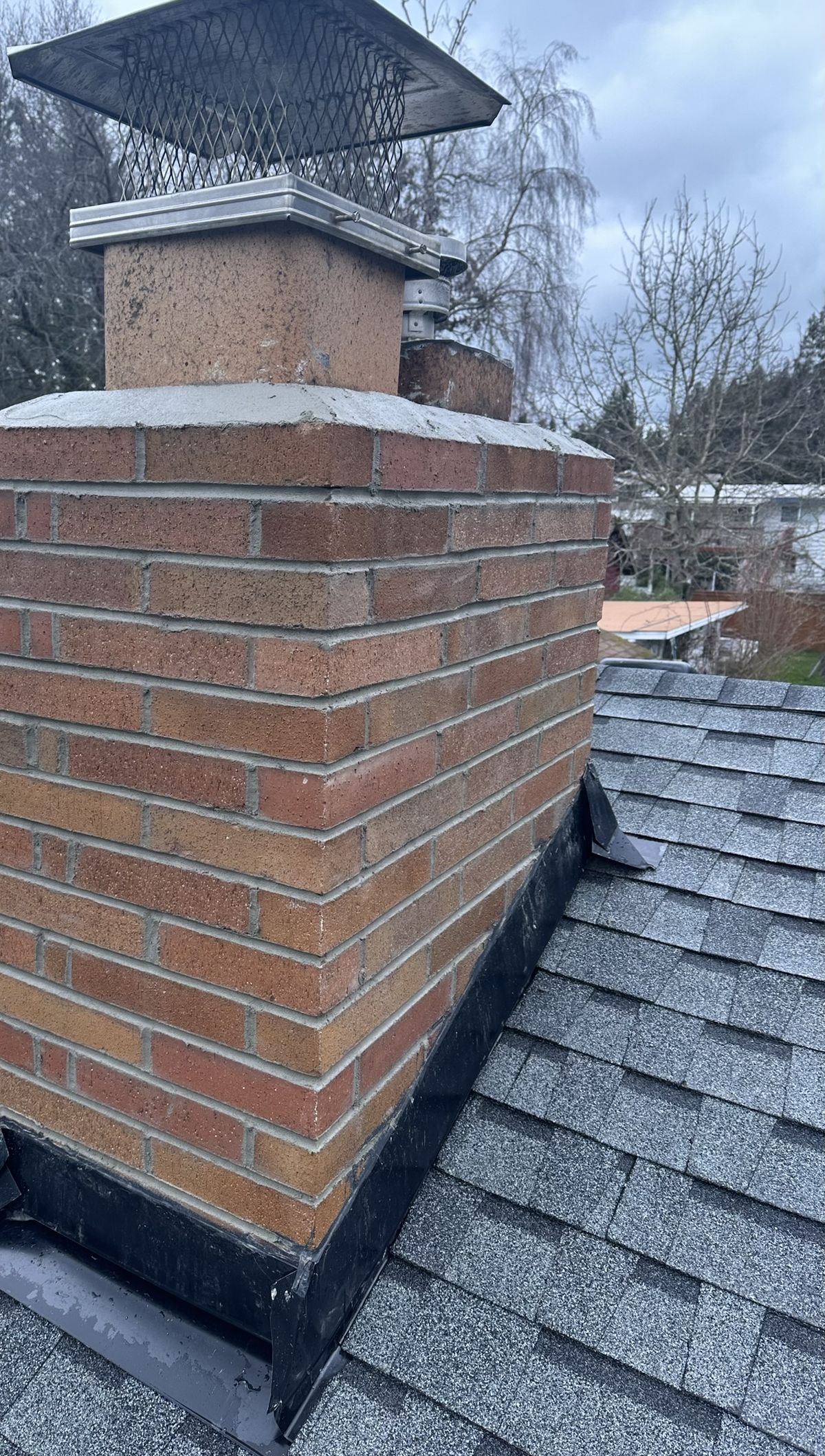 Professional flashing installation on brick chimney